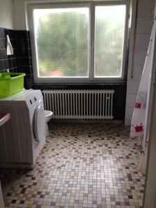 ein Bad mit einer Waschmaschine und einem Fenster in der Unterkunft Neureut in Karlsruhe