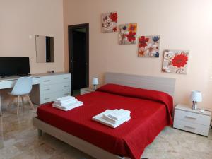 a bedroom with a red bed with a desk and a computer at Arte Mia B&B in Reggio di Calabria