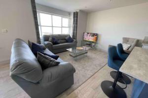 un soggiorno con due divani e una televisione di The Loft Cottage a Glastry