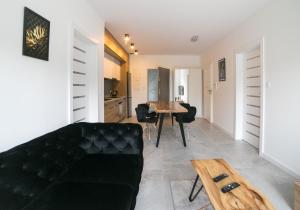 a living room with a black couch and a table at Oxygen apartament nr 2 in Mielec
