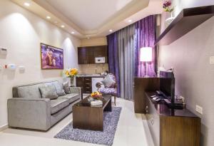 ein Wohnzimmer mit einem Sofa und einem Tisch in der Unterkunft Nadine Hotel Suites in Amman