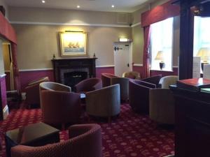 a waiting room with chairs and a fireplace at Hardwicke Hall Manor Hotel in Hartlepool +7 photos