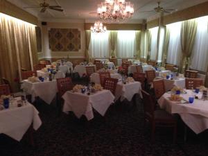 una sala de banquetes con mesas y sillas blancas y una lámpara de araña en Hardwicke Hall Manor Hotel, en Hartlepool