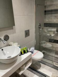 un bagno con lavandino, WC e doccia di V-Suites a Potos Altre 63 foto