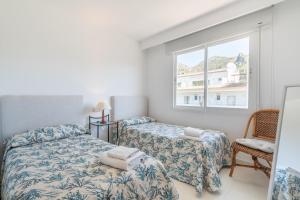 a bedroom with two beds and a window at Isabela 2b-3 habitaciones con ático in Port de Pollensa