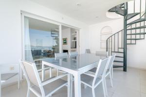 een eetkamer met een glazen tafel en witte stoelen bij Isabela 2b-3 habitaciones con ático in Port de Pollença