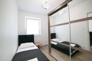 a bedroom with two beds and a mirror at Oxygen apartament nr 2 in Mielec