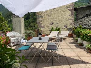 einen weißen Tisch und Stühle auf einer Terrasse in der Unterkunft Dagli Olivari - Casa Dani in Gromo