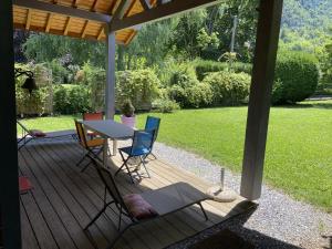 una terraza de madera con mesa y sillas. en Le Chalet du Roc, en Duingt