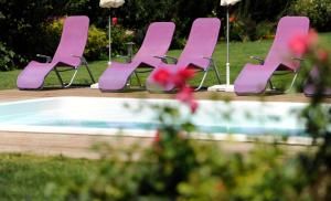 un groupe de chaises roses assises à côté d'une piscine dans l'établissement Zum goldenen Engel - Fam. Ehrenreich, à Krems an der Donau