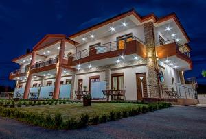 a large house with lights on it at night at Anthemida Rooms in Sykia Chalkidikis