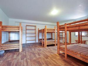 a room with four bunk beds and wooden floors at Claudi´s Radl Stadl in Kressbronn am Bodensee