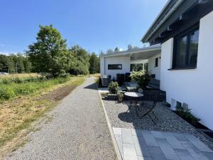 eine Terrasse mit einem Tisch und Stühlen neben einem Haus in der Unterkunft Casa Verde - Moos in Moos