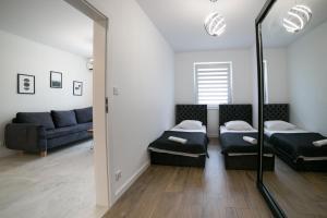 - un salon avec deux lits et un canapé dans l'établissement Oxygen apartament nr 3, à Mielec