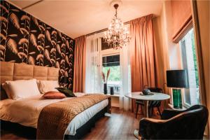 een slaapkamer met een bed, een tafel en een kroonluchter bij Short Stay Apartments Heerenveen in Heerenveen