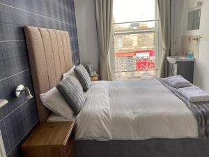 Un dormitorio con una cama grande y una ventana en Edinburgh Rays Guest House, en Edimburgo