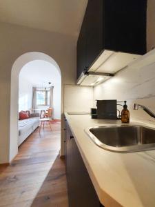 eine Küche mit einem Waschbecken und ein Wohnzimmer in der Unterkunft Gruberwirt Apartments in Innsbruck