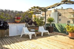 un patio con 2 sillas blancas y una mesa en Los Condes Penthouse by Hello Homes Sitges en Sitges
