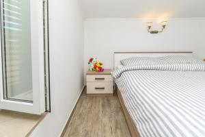 1 dormitorio con 2 camas junto a una ventana en Beautiful Apartment Aleks, en Mali Lošinj