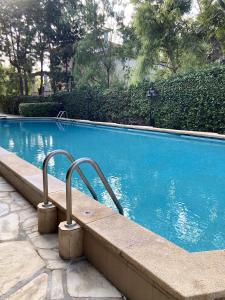 a large blue swimming pool with metal hand rails at Los Globos Beach Studio by Hello Homes Sitges in Sitges