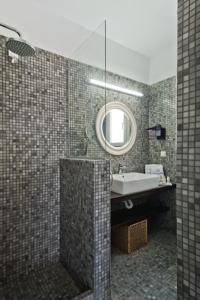 ein Bad mit einem Waschbecken und einem Spiegel in der Unterkunft Amoopi Nymfes Royal in Amoopi