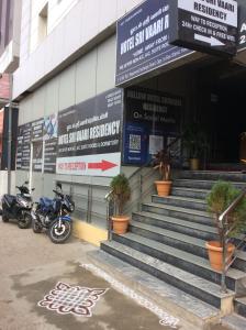 a motorcycle parked in front of a building at HOTEL SRI VAARI RESIDENCY in Hosūr