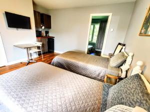 a hotel room with two beds and a desk at Salmon River Motel in Shannonville