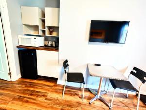 a room with chairs and a table and a microwave at Salmon River Motel in Shannonville