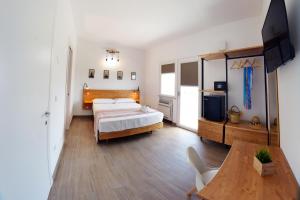 a bedroom with a bed and a table and a television at Dimora EFFE - Eco B&B in Termoli