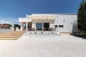 a white house with a patio and stairs at B&B Foglie D’ulivo in Lizzano