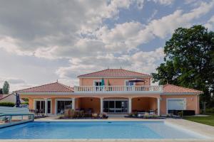 a large house with a swimming pool in front of it at VILLA DES CHENES in Saint-Doulchard