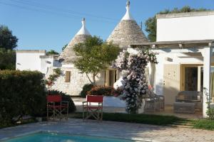 a house with a pool in front of it at Trulli La Pietraia in Ostuni