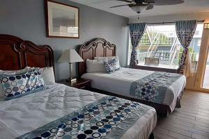 a hotel room with two beds and a balcony at Sunset Beach Hotel in Wildwood