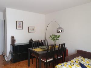 - une salle à manger avec une table, des chaises et un canapé dans l'établissement Stunning Studio Apartment, à Veyrier