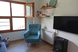 un salon avec une chaise bleue et une télévision dans l'établissement Inmocyma Ibonet-Cerler, à Cerler