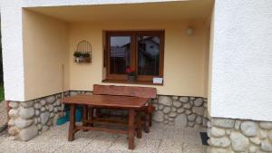 a wooden table and a bench in a window at Sifra 276 in Nová Lesná