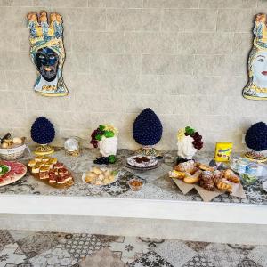 uma mesa coberta com pratos de comida e sobremesas em b&b I Mori em Noto Marina