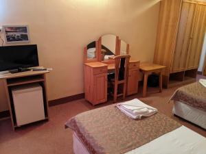 Cette chambre comprend un bureau et un miroir. dans l'établissement Hotel Palma Weiss, à Kranevo