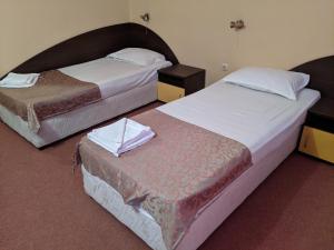 two beds in a hotel room withskirts at Hotel Palma Weiss in Kranevo