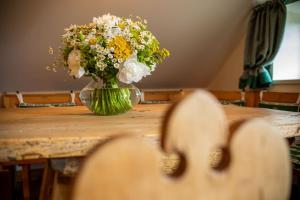 un jarrón de flores sentado sobre una mesa en Der Knappenhof - Hotel & Restaurant, en Reichenau