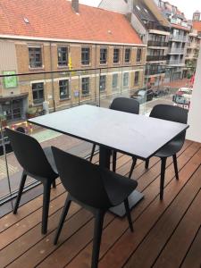 d'une table et de chaises sur un balcon avec vue sur un bâtiment. dans l'établissement bloc 79/one, à Knokke-Heist