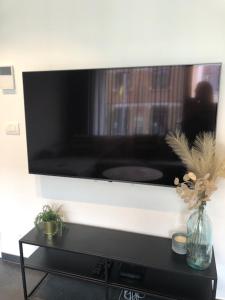 een flatscreen-tv aan een muur in een woonkamer bij bloc 79/one in Knokke-Heist