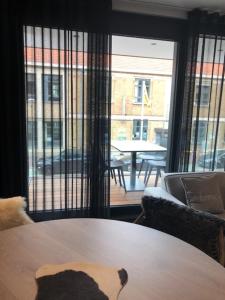 a table and chairs in a room with a large window at bloc 79/one in Knokke-Heist +6 photos