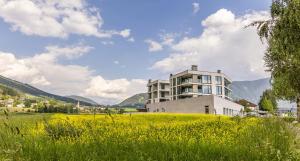 ein Gebäude auf einem Hügel mit einem Feld in der Unterkunft Bellevue Bruneck - Suites & Lofts in Bruneck
