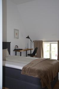 a bedroom with a bed with a desk and a chair at Wersauer Hof - Ferme Auberge in Reilingen