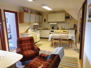a kitchen with a couch and a table and chairs at Rooms for rent in Bø