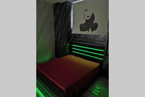 Cette chambre comprend un lit avec des draps verts et rouges. dans l'établissement Camera relax Fuorigrotta, à Naples