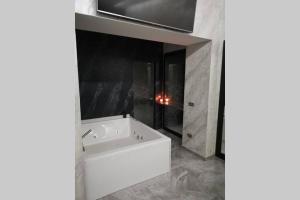 La salle de bains est pourvue d'une baignoire blanche et d'une fenêtre. dans l'établissement Camera relax Fuorigrotta, à Naples