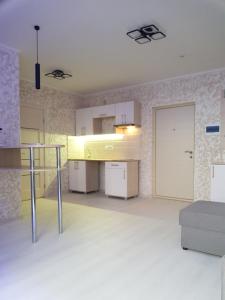 Cette grande chambre dispose d'une cuisine avec des placards blancs. dans l'établissement apart-hotel Sky, à Youjne