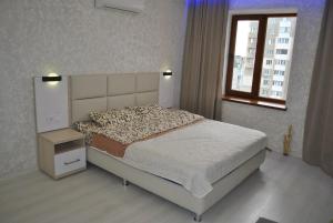 um quarto com uma cama grande e uma janela em apart-hotel Sky em Yuzhne